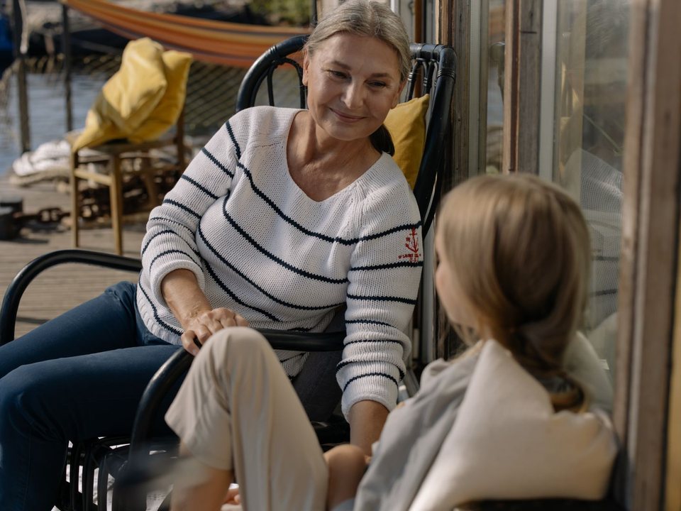 A grandmother talking with her granddaughter on the porch