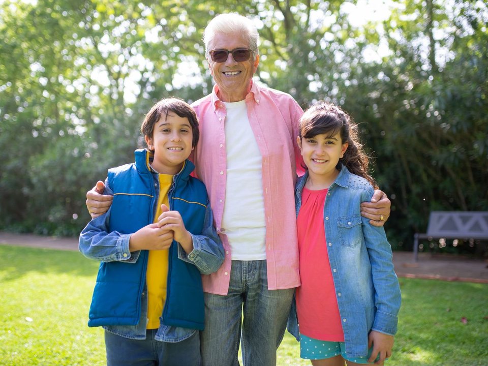 A grandfather with his two grandchildren in the park